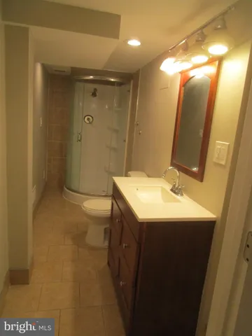 a bathroom with a sink and mirror with toilet