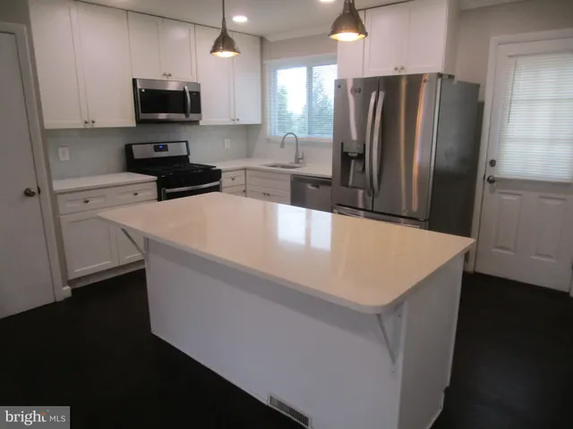 a kitchen with stainless steel appliances a refrigerator sink and microwave