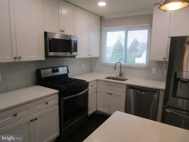 a kitchen with a sink stove and microwave