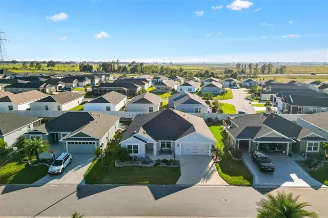 an aerial view of residential houses with outdoor space and ocean view