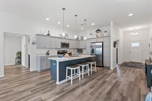 a kitchen with kitchen island a refrigerator and a stove top oven