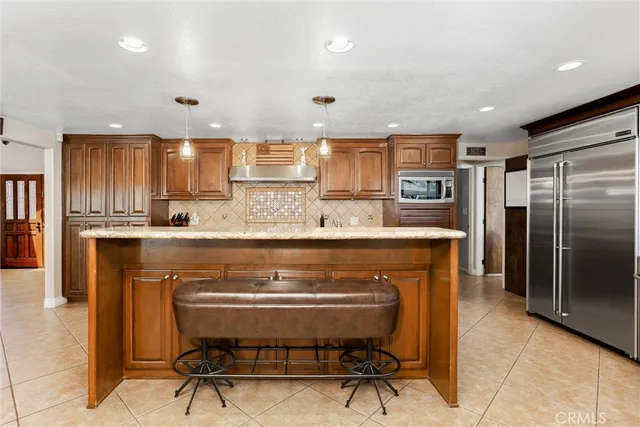 a kitchen with kitchen island granite countertop a sink counter top space appliances and a large window