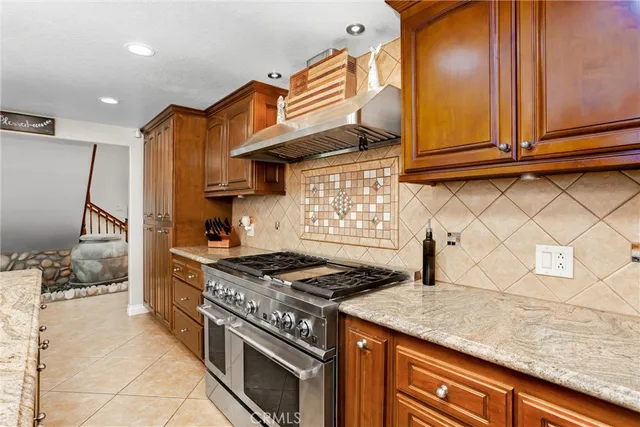 a kitchen with stainless steel appliances granite countertop a sink and a refrigerator