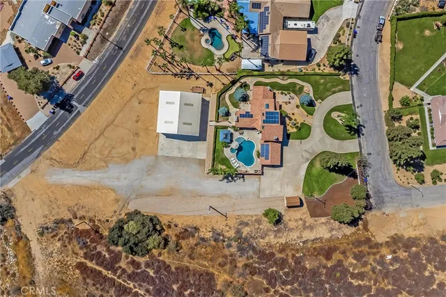 an aerial view of residential houses with outdoor space and trees