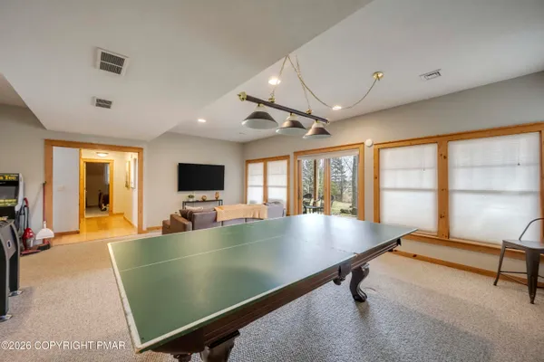 a room with pool table and windows