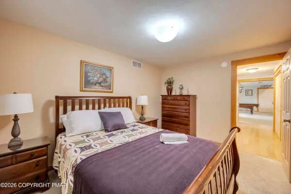 a bedroom with a bed and a lamp with dresser