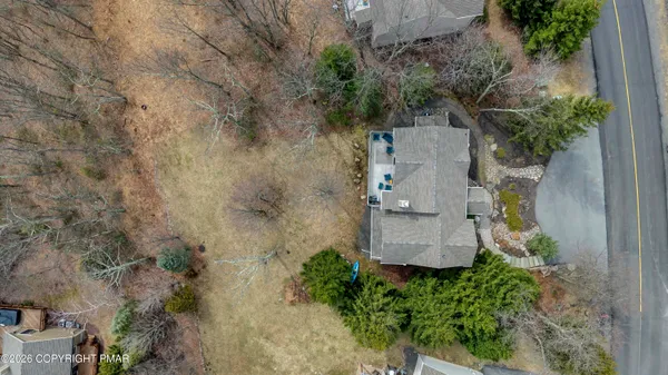an aerial view of a house with a yard and trees