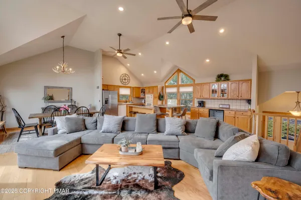 a living room with furniture kitchen view and a chandelier