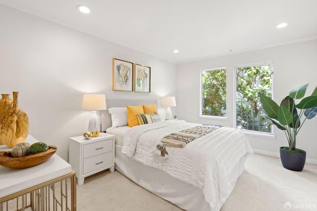 a bedroom with a bed and a potted plant