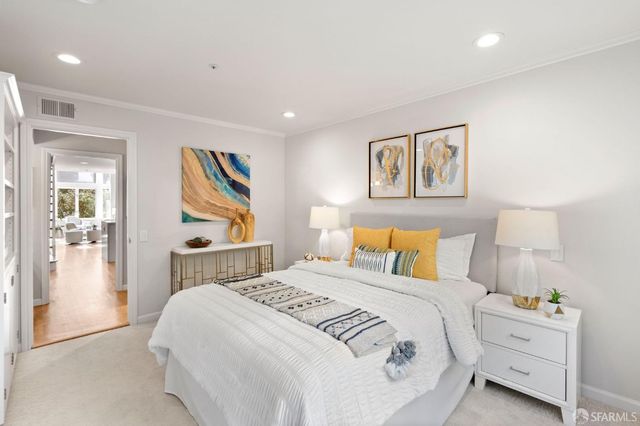 a bedroom with a bed and painting on the wall