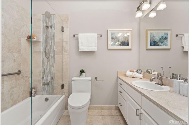 a bathroom with a bathtub shower sink mirror and toilet