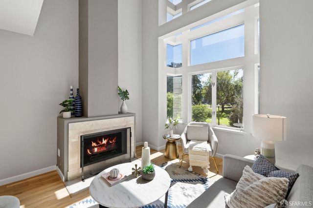a living room with furniture a fireplace and a large window