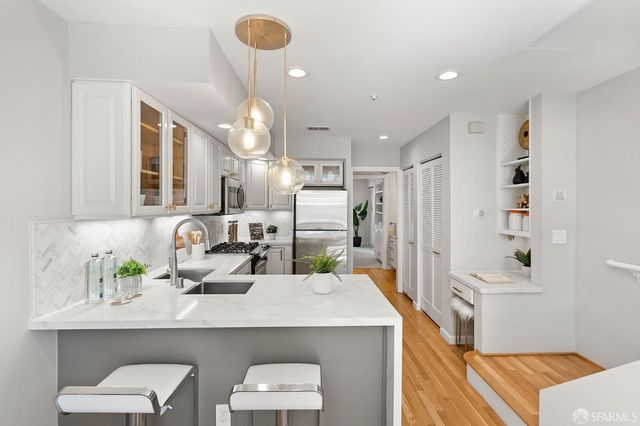 a kitchen with kitchen island stainless steel appliances a sink and cabinets