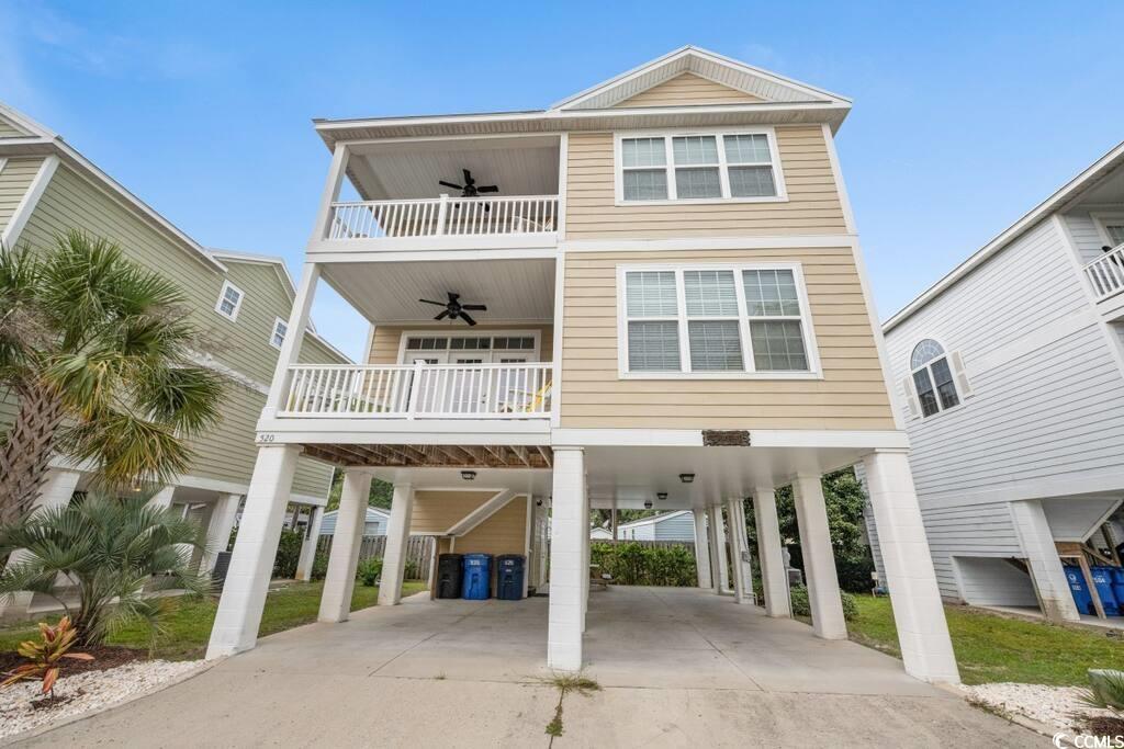 520 Caribbean Way Myrtle Beach, SC 29577 - Photo 1 of 21 View of front of property with a carport, ceiling fan, concrete driveway, a balcony, and stairway