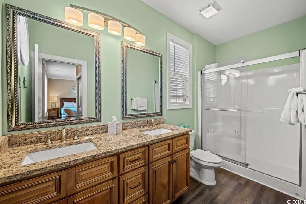 520 Caribbean Way Myrtle Beach, SC 29577 - Photo 11 of 21 Bathroom featuring double vanity, connected bathroom, a shower stall, and dark wood-type flooring