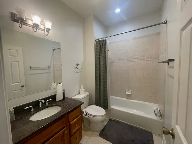 a bathroom with a granite countertop sink toilet a shower and a mirror