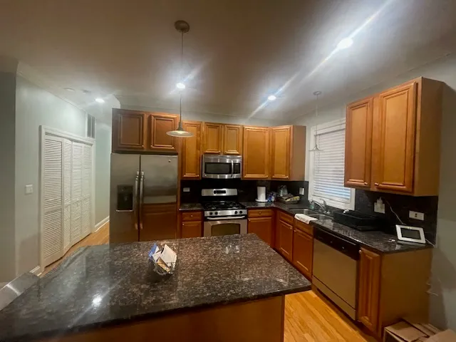 a kitchen with kitchen island granite countertop a sink stove and refrigerator