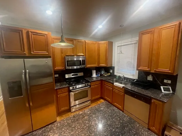 a kitchen with granite countertop stainless steel appliances and wooden cabinets