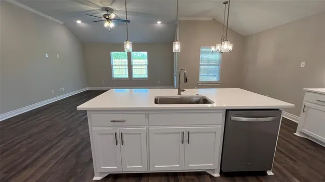 a kitchen with a sink chandelier and wooden floor