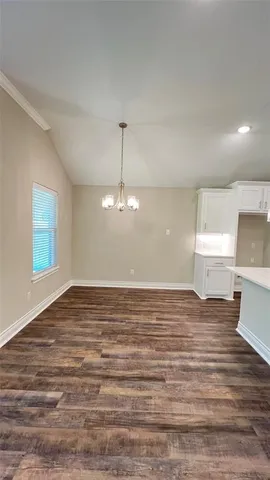 a view of a room with wooden floor and chandelier
