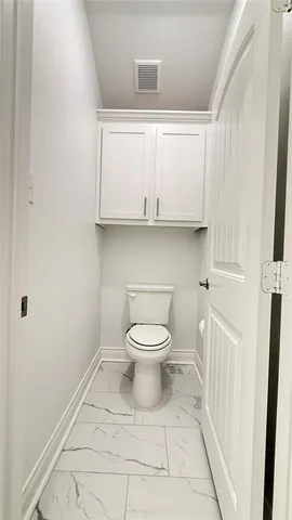 a bathroom with a toilet a sink and a window