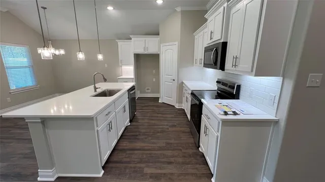 a kitchen with stainless steel appliances a sink a stove and a refrigerator