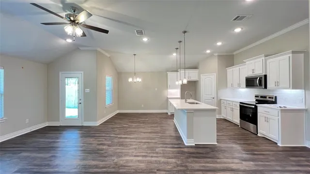 a view of kitchen with stainless steel appliances refrigerator stove microwave and cabinets