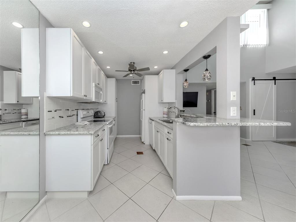 1555 Tarpon Center Drive, Unit 255 Venice, FL 34285 - Photo 16 of 57 a kitchen with cabinets and white appliances