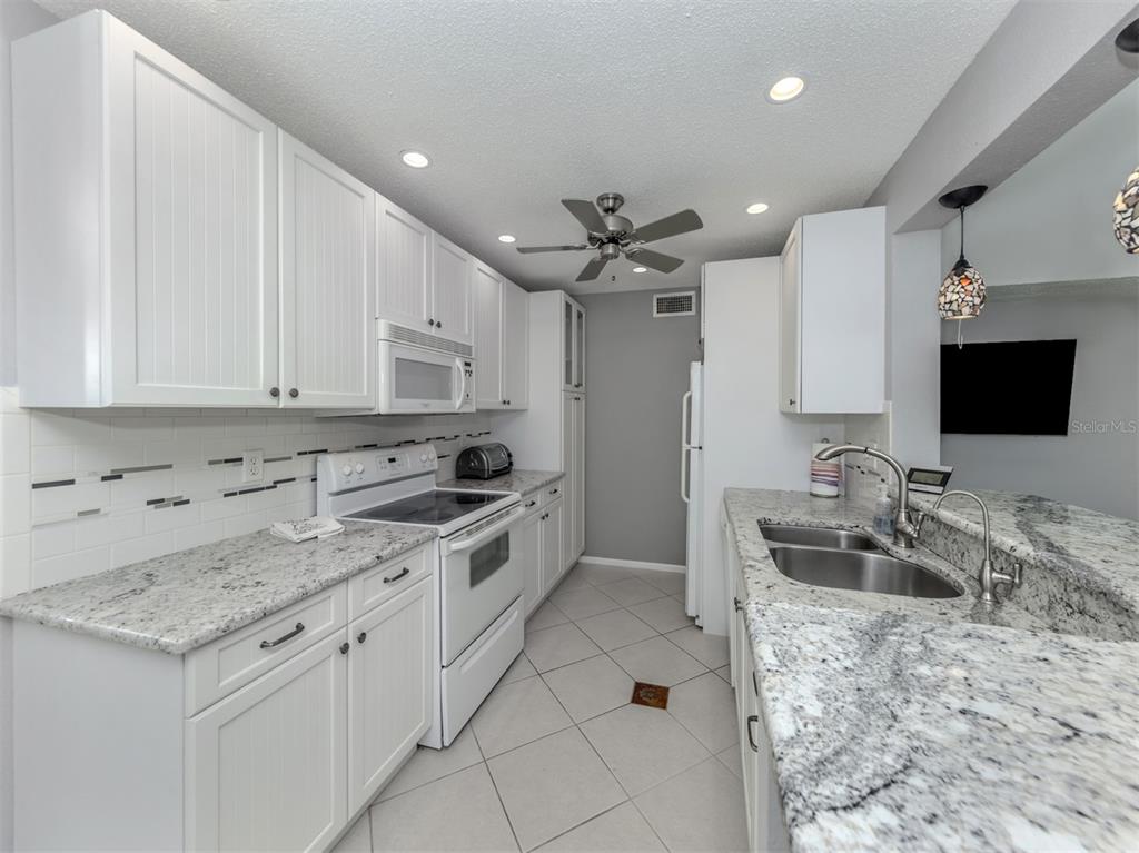 1555 Tarpon Center Drive, Unit 255 Venice, FL 34285 - Photo 17 of 57 a kitchen with granite countertop a sink appliances and cabinets