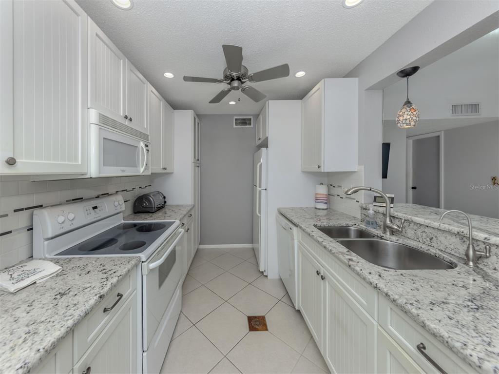 1555 Tarpon Center Drive, Unit 255 Venice, FL 34285 - Photo 18 of 57 a kitchen with a sink stove top oven and cabinets