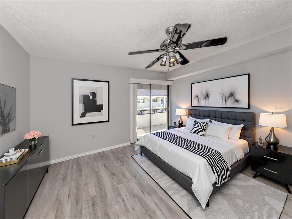 1555 Tarpon Center Drive, Unit 255 Venice, FL 34285 - Photo 21 of 57 a bedroom with a large bed and a chandelier