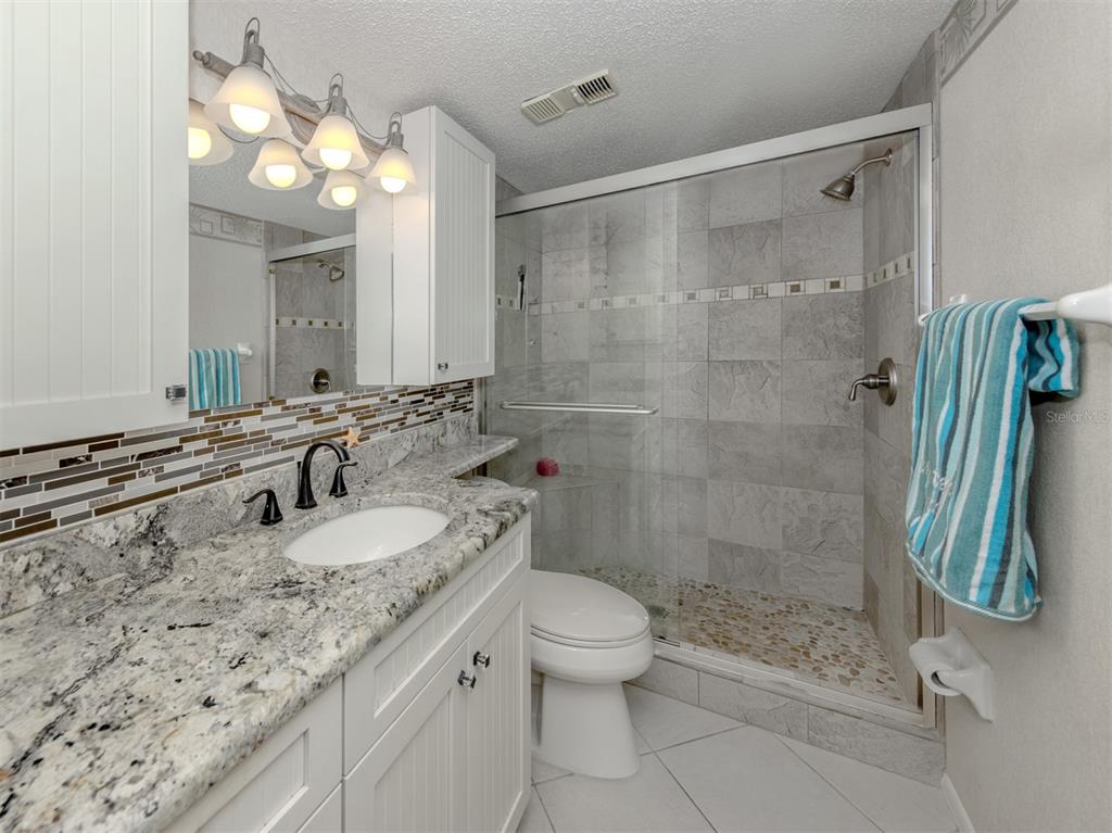 1555 Tarpon Center Drive, Unit 255 Venice, FL 34285 - Photo 23 of 57 a bathroom with a granite countertop sink toilet and shower