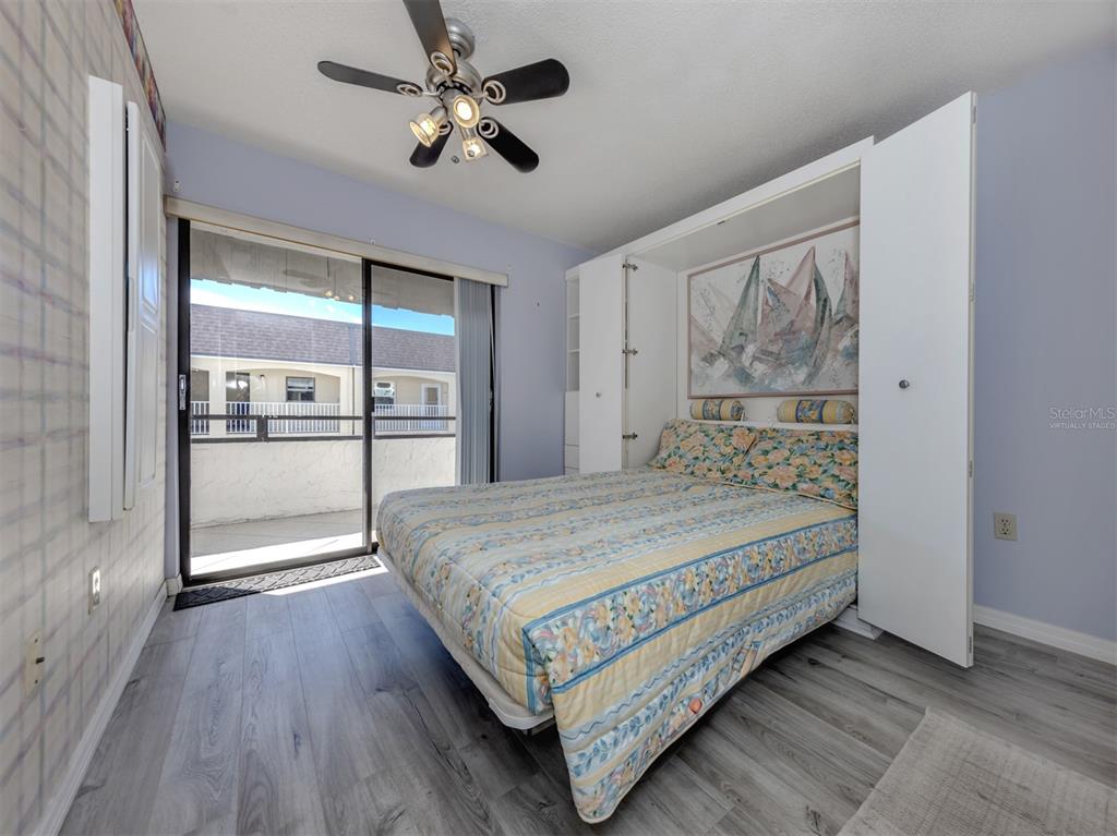 1555 Tarpon Center Drive, Unit 255 Venice, FL 34285 - Photo 25 of 57 a bedroom with a large bed and a chandelier