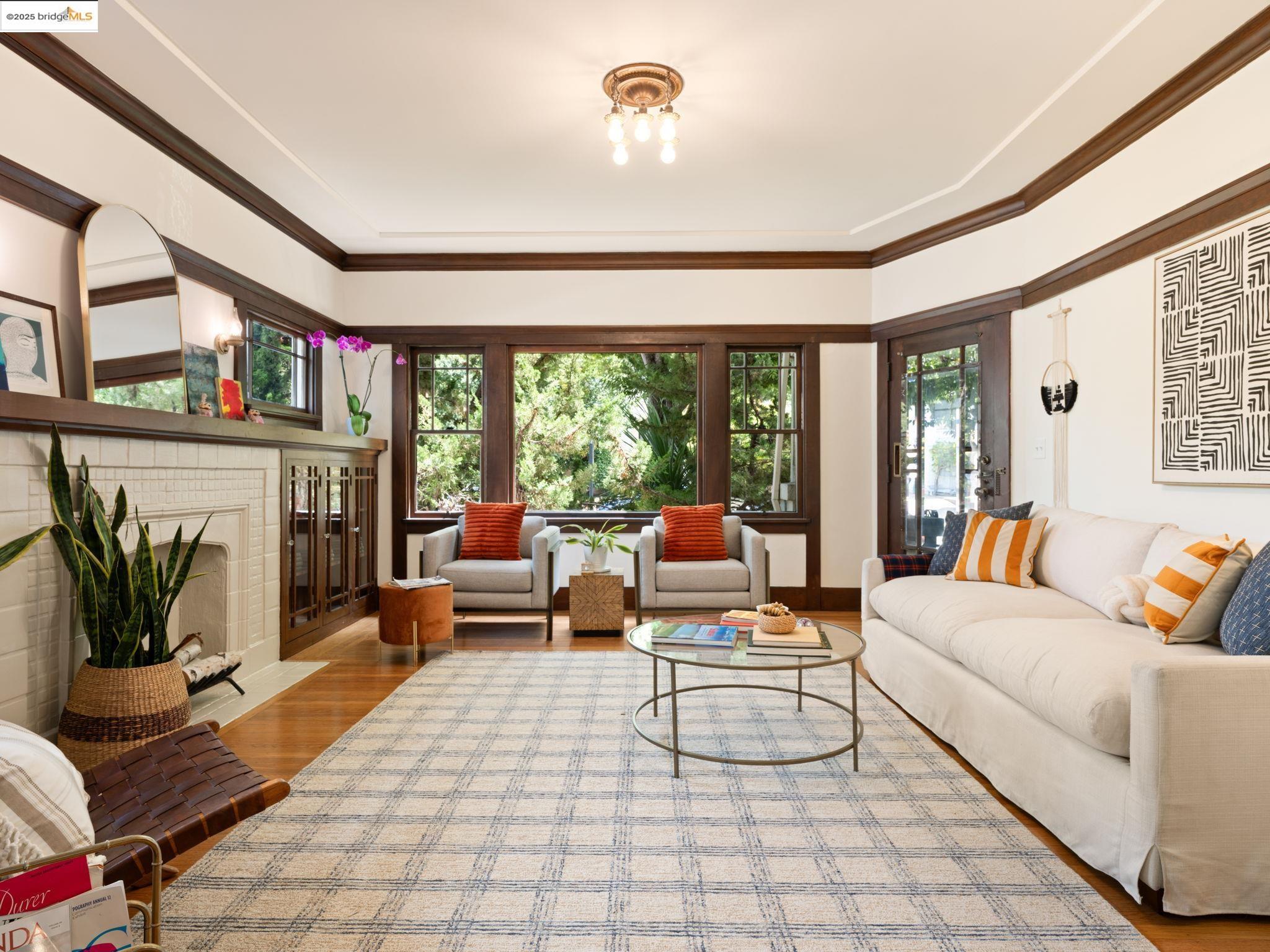 a living room with furniture a rug a fireplace and a large window