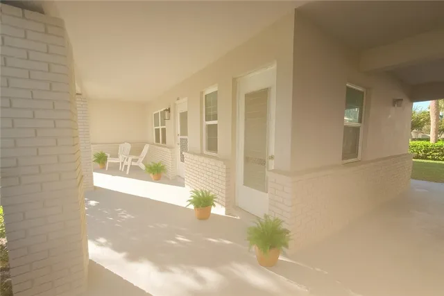 a view of a hallway with wooden floor and a living room