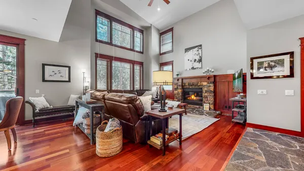 a living room with furniture a large window and wooden floor