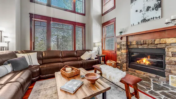 a living room with furniture a fireplace and a large window