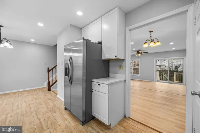 a kitchen with stainless steel appliances a refrigerator and a wooden floor