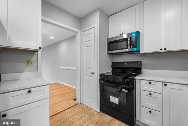 a kitchen with stainless steel appliances white cabinets and stove