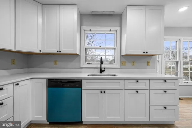 a kitchen with white cabinets and a sink