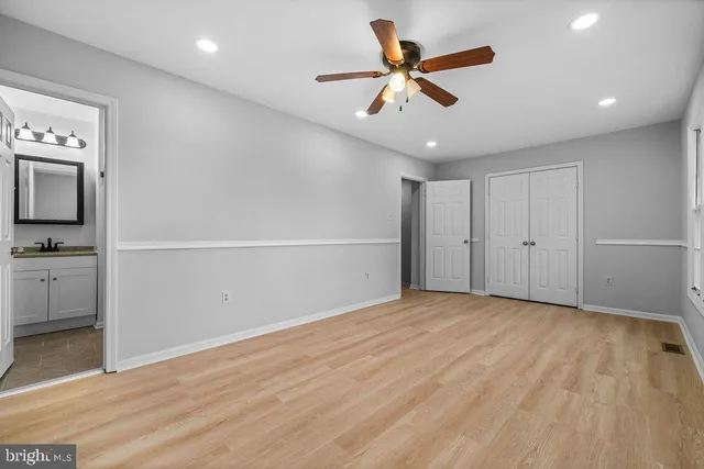 a view of a livingroom with a ceiling fan wooden floor and a ceiling fan