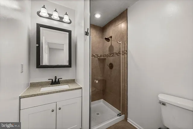a bathroom with a toilet sink vanity and mirror