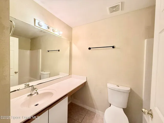 a bathroom with a sink mirror vanity and toilet
