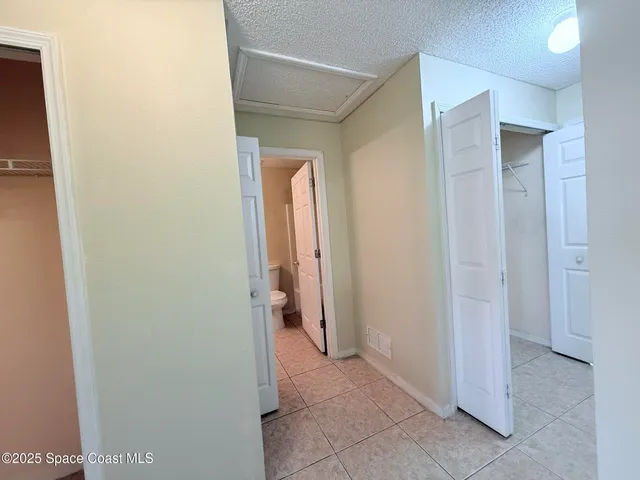 a view of a hallway with closet and bathroom