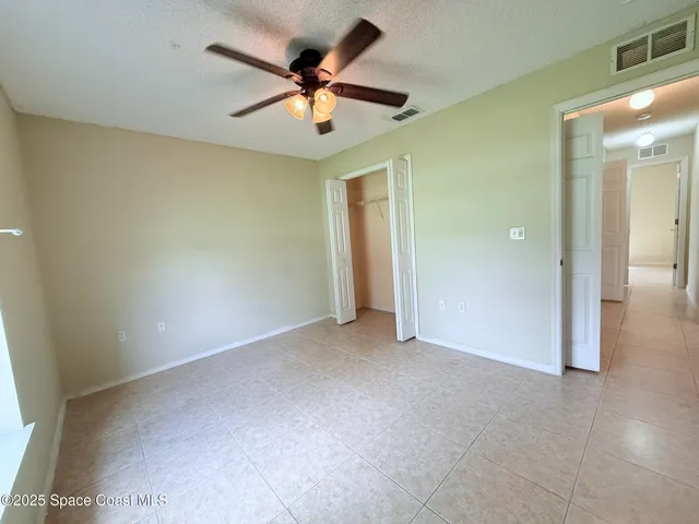 an empty room with closet and a ceiling fan