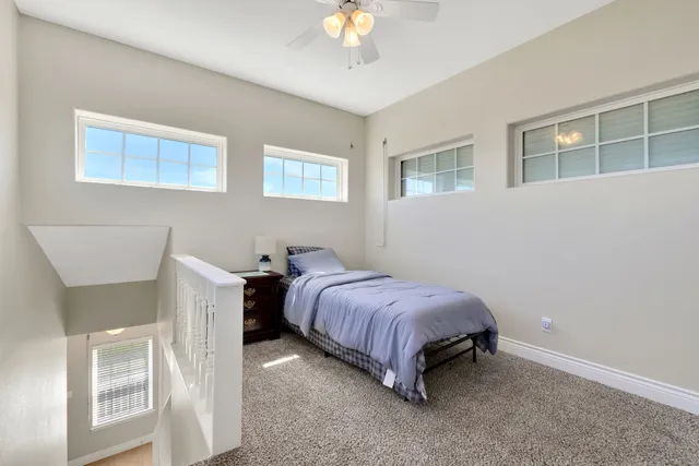 a spacious bedroom with a bed and a chandelier