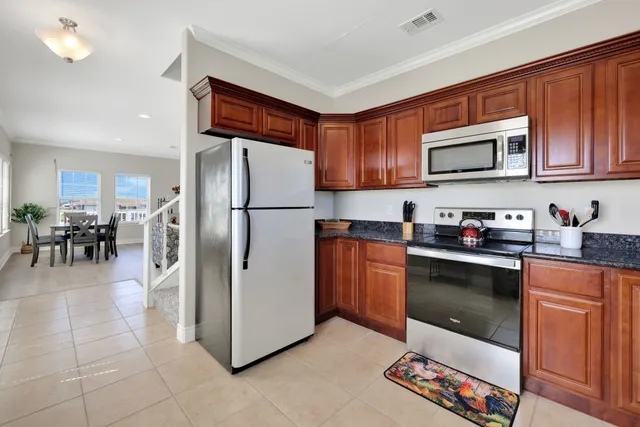 a kitchen with stainless steel appliances granite countertop a refrigerator stove top oven a sink and dishwasher