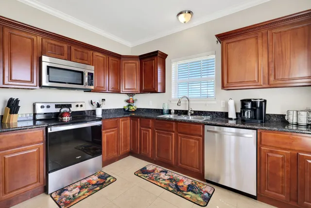 a kitchen with stainless steel appliances granite countertop a stove a sink dishwasher and a microwave oven on the granite countertops