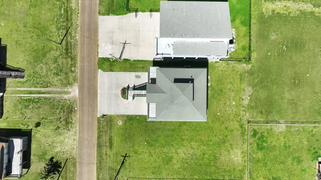 an aerial view of residential houses with outdoor space and trees