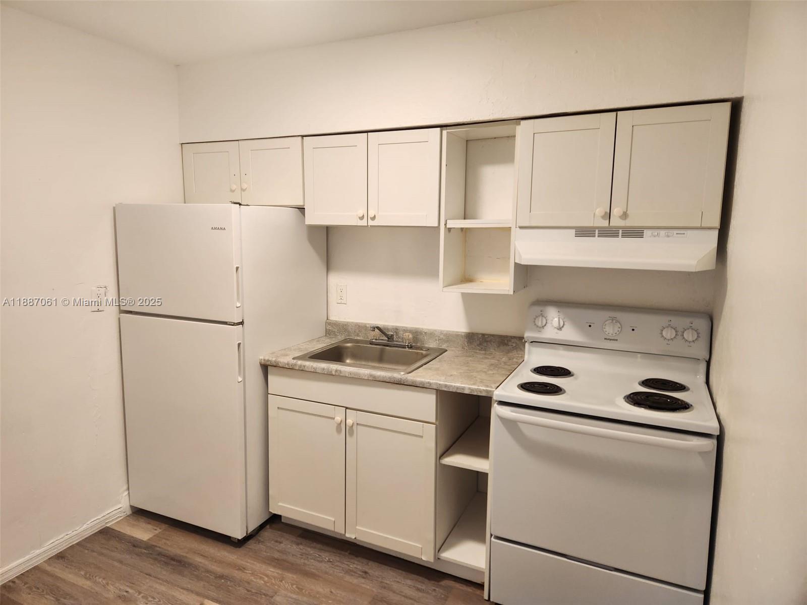 2640 Northwest 2nd Street, Unit 3 Pompano Beach, FL 33069 - Photo 2 of 9 a kitchen with a stove and a refrigerator